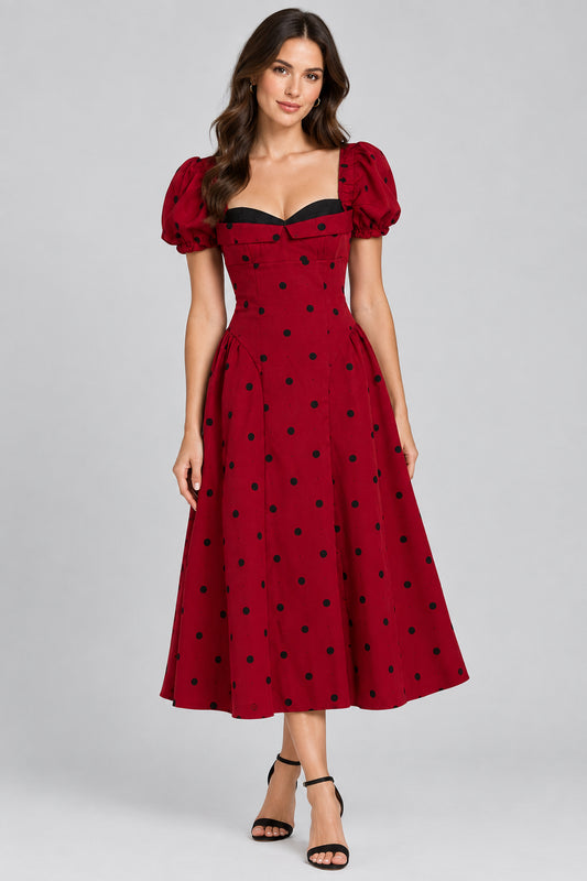 Cherry red long dress with black polka dots, a contrast neckline and puff sleeves.